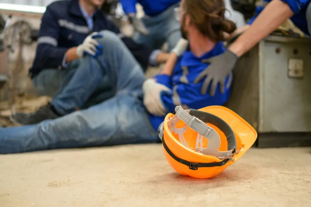 An orange hard hat lies upside down on the floor in the foreground.